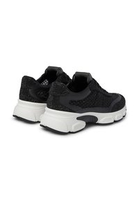 Black sneakers featuring a textured mesh upper, smooth black accents, and a chunky white sole with distinct tread patterns.