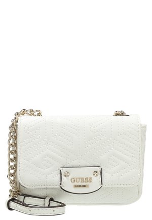 Sac bandoulière matelassé blanc avec une chaîne dorée et une plaque métallique portant l'inscription "GUESS EST. 1981" sur le rabat avant.