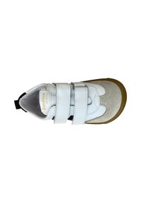 Zapatilla blanca de cuero con dos tiras de Velcro, una puntera de ante beige y suela de goma. Detalles en negro en la zona del talón.