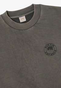 Σκούρο πράσινο φούτερ με στρογγυλή λεένα και ριμπ μανσέτα, με μικρό μαύρο λογότυπο "BLKVIS EST. 2019" που απεικονίζει ένα δέντρο στο στήθος.