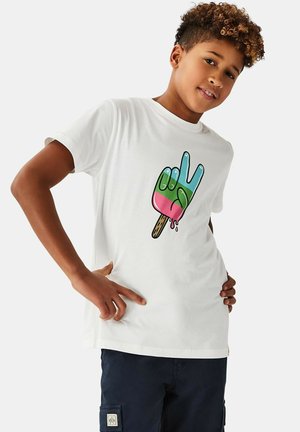 Dreng med krøllet hår iført en hvid T-shirt med et farverigt smeltende is på pind formet som en hånd, der laver et rock-tegn.