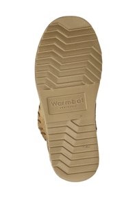 Lichtbruine rubberen schoenzool met een zigzagprofiel, met een gegraveerd "Wombat Australia" merk vlakbij de hiel.