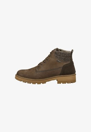 Bottes chelsea brunes en suède et tissu, avec un dessus texturé, une partie inférieure lisse, un col rembourré et une semelle en caoutchouc.