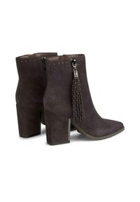 Botines de ante grises con punta cuadrada, tachuelas decorativas en la parte superior y detalle de borlas; cuentan con un tacón cuadrado.