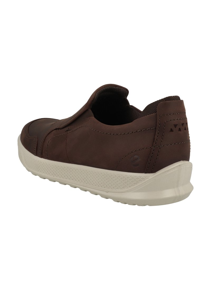Brun lädersko med en slip-on design, texturerade accenter och en kontrasterande vit gummisula; har minimala sömnadsdetaljer.