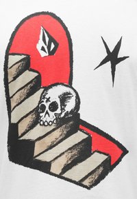 T-shirt blanc arborant un graphisme d'escaliers et un crâne sur un fond rouge avec des accents et des détails noirs, mettant en valeur la profondeur et la texture.