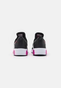 Zapatillas deportivas negras con una superficie texturada, detalles en rosa y una suela blanca, que cuentan con una pestaña en el talón para ponérselas fácilmente.