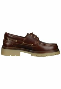 Braune Lederbootsschuhe mit runder Zehenpartie, goldenen Ösen und einer beigefarbenen Gummisohle mit strukturiertem Muster.