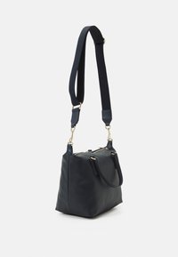 Navyblaue Schultertasche aus weichem Material mit zwei Griffen und einem abnehmbaren, verstellbaren Schulterriemen. Mit goldenen Hardware-Akzenten.