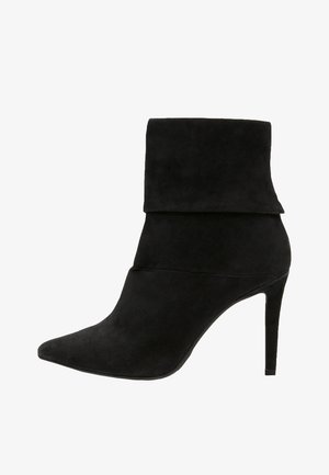Musta mokkanahkainen naisten nilkkabooti, jossa on kärki, taitettu varsi ja stiletto-korko.