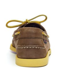Scarpa da barca in cuoio marrone con accenti gialli; presenta una cucitura in stile mocassino, punta rotonda e lacci gialli sottili. Suola piatta gialla.