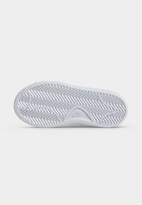 Σόλα λευκού παπουτσιού Nike με σχέδιο ψαροκόκαλου και λογότυπο Nike στη μέση, εμφανίζεται σε λευκό φόντο.