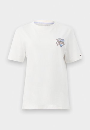 T-shirt bianco in cotone con maniche corte, caratterizzato da un design ricamato in blu e rosso sul petto e un dettaglio a righe sul colletto.