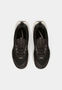 Zwarte sportieve schoenen met een gestructureerde bovenkant, reflecterende accenten en een gespikkelde zool. Voorzien van een veilige vetersluiting en een versterkte neus.