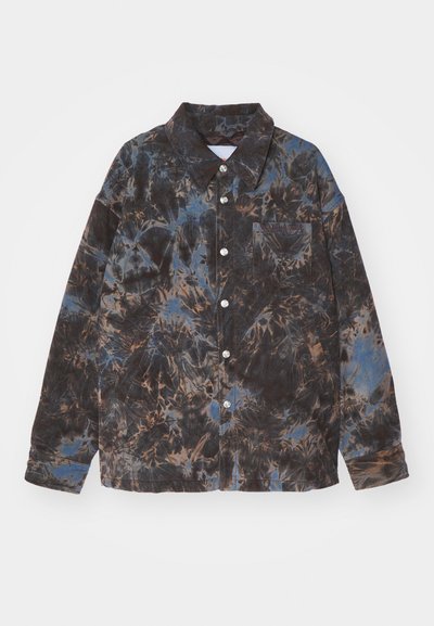 Button-up shirt in corduroy, featuring a multicolored pattern of brown, blue, and black. Includes a collar and front pocket with label.