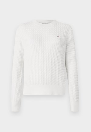 Hvid strikket sweater med et struktureret kabelmønster, rund hals og lange ærmer. Har et lille broderet logo på brystet.