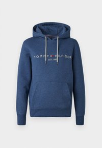 Marineblauwe Tommy Hilfiger hoodie met een voorzak, capuchon met trekkoord en de tekst "Tommy Hilfiger Est. 1985" over de borst.