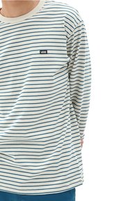Camisa de manga larga a rayas en crema y azul, con un escote redondo y un pequeño logo negro de Vans en el pecho. Textura de tela suave.