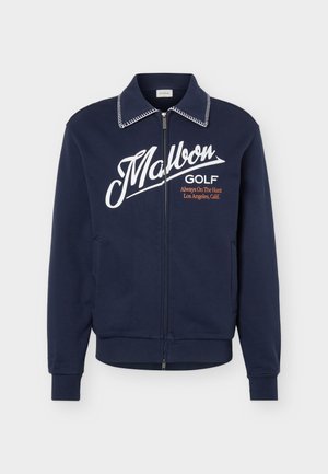 Mornarska jakna na patent s bijelim šavom na ovratniku, velikim bijelim tekstom "Malbon", manjim natpisom "GOLF Always On The Hunt Los Angeles, Calif." na prsima.