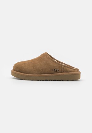 Brown suede slip-on clogs with a soft interior lining, rubber outsole, and minimal stitching details. UGG logo on the side.