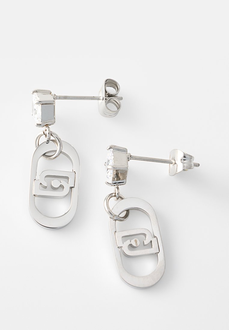 Boucles d'oreilles en ton argent, présentant une forme rectangulaire avec un design ovale lié, accentuées par un cristal transparent en stud en haut.