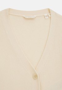 Cardigan a coste crema con scollo a V, dotato di chiusura con un bottone. Realizzato in materiale morbido con una texture liscia. Etichetta visibile all'interno.