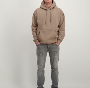 Tan hoodie met een voorzak, trekkoorden en geribde manchetten; gecombineerd met lichtgrijze versleten jeans. Effen achtergrond.