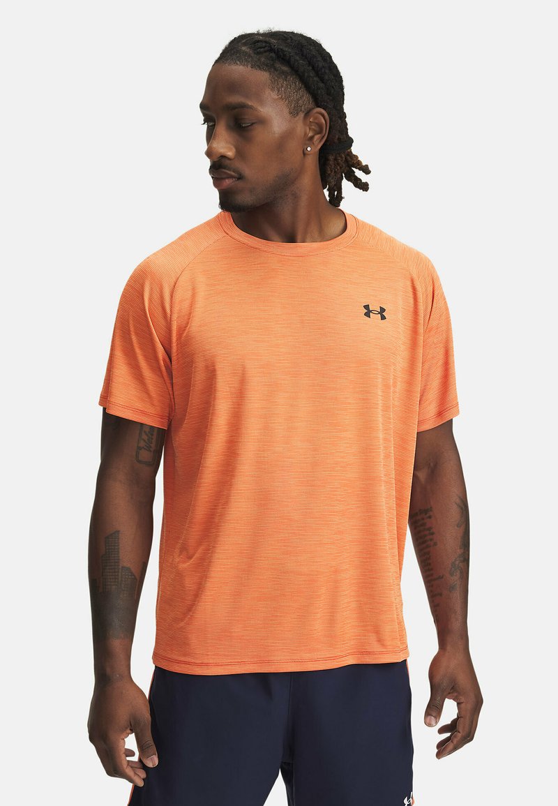 Camiseta deportiva de manga corta para hombres en un vibrante color naranja con un sutil patrón de rayas, escote redondo y logo negro en el pecho.