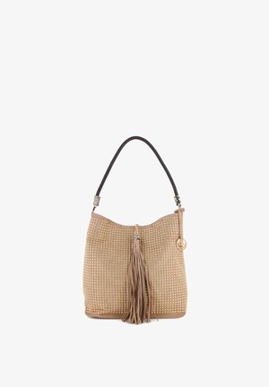 Bolso de ante beige con tachuelas doradas, asa trenzada negra, borla central de ante y un pequeño colgante dorado redondo en el lateral.