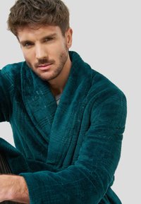 Bata de plush en color azul verdoso con textura acolchada, cuello ancho y mangas largas. Presenta un acabado de tela rica y un ajuste cómodo.