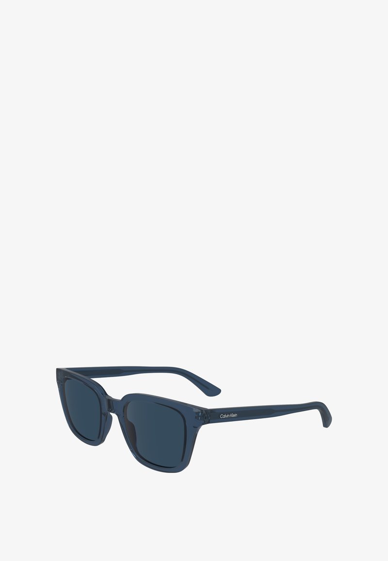 Marineblaue rechteckige Sonnenbrillen mit dunklen Gläsern, ausgestattet mit einem transparenten Rahmen und subtilem Branding an den Schläfen. Klassisches Design mit geraden Bügeln.