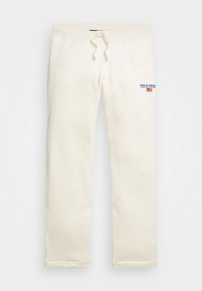 Mīksti kokvilnas sporta bikses krēmkrāsā, ar auklu jostasvietā, taisnām kājām un zilo un sarkano "POLO SPORT" logotipu priekšpusē.