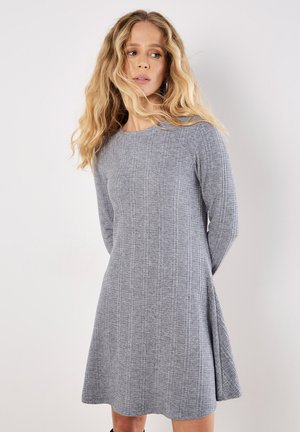 Grau gestricktes Kleid mit langen Ärmeln, rundem Ausschnitt und ausgestelltem Saum. Verfügt über ein strukturiertes Rippmuster und seitliche Schlitze für mehr Bewegungsfreiheit.