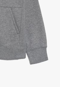 Grå sweatshirt med en mjuk textur, med en framficka, ribbade ärmslut och nederkant, med en enkel, avslappnad design.