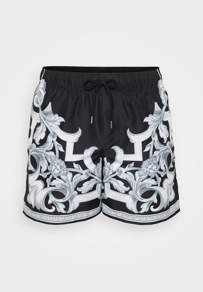 Shorts de bain noirs ornés de motifs floraux baroques blancs intricats. Taille élastique avec cordon de serrage ajustable et accents de quincaillerie décoratifs.