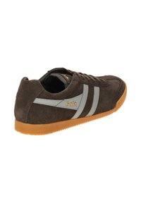 Zapatillas de ante marrón con rayas grises, puntera redonda y suela de goma texturizada en naranja. Presenta una marca en el lateral.