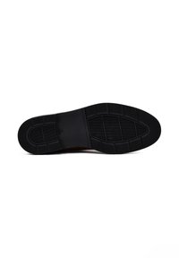 Suola di scarpa nera in gomma con pattern testurizzati e scanalature, caratterizzata da una forma ovale e un tallone rinforzato per durata e trazione.