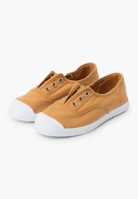 Chaussures à enfiler en toile de couleur jaune moutarde avec des semelles et des bouchons de protection blancs. Présente un design à double œillet pour une utilisation facile.