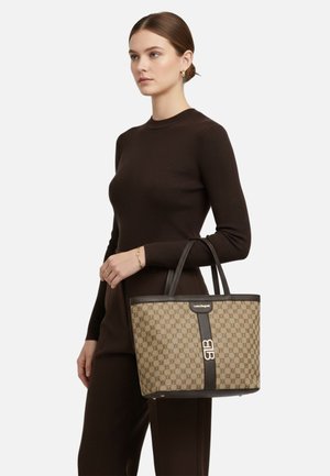 Borsa tote marrone con motivo a fantasia, manici in pelle, con un dettaglio logo dorato e fascia nera a contrasto. La trama del tessuto è liscia.
