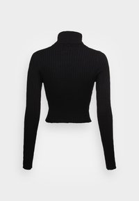 Svart ribbad polotröja med långa ärmar, figursydd design och kort längd, som visar en texturerad tyg.