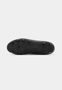 Black athletic shoe sole with molded studs for traction, featuring a textured surface and subtle green accents along the sides.