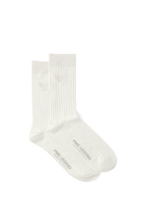 Paire de chaussettes blanches côtelées avec un logo ailé près du haut et "PME Legend American Classic" imprimé sur les semelles.