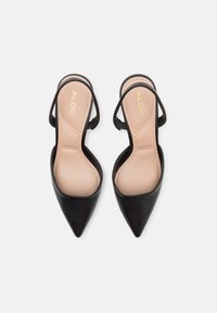 Scarpe slingback nere a punta con finitura in pelle liscia, dotate di un'insole nude e di sottili cinturini neri. Logo stampato sull'insole.