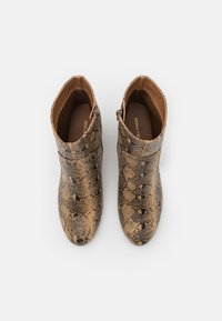 Brown and tan snake-print ankle boots with a smooth texture, rounded toe, and side zip closure. Leather-like material with a slip-on design.