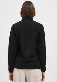 Pull en polaire noir avec un col haut, une texture douce et des manches longues. Présente une coupe droite avec un ourlet plat et sans matériel visible.