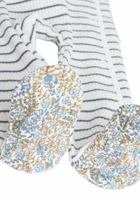 Gestreepte romper in witte en grijze stof met een bloemige voetdetail in blauwe en beige tinten. Zachte, ribbelige textuur.