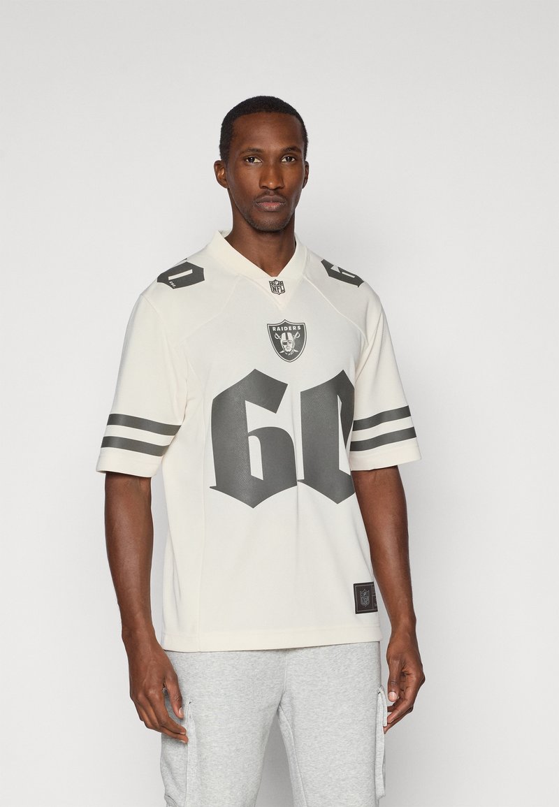 Kremowa koszulka NFL z logo Raiders, z wyraźnym szarym numerem "60" oraz czarnymi i szarymi paskami na rękawach.