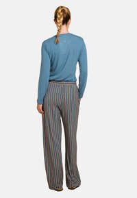 Blauw langemouwtop met een relaxte pasvorm, gecombineerd met multicolore gestreepte wijde broek met een comfortabele elastische tailleband.