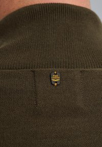 Olive zielony sweter wykonany na drutach z prążkowanym dekoltem, z naszywką z logo PME Legend wszytą blisko kołnierza. Teksturalna tkanina.