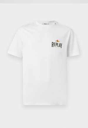 Vit bomullströja med korta ärmar, som har en svart och gul "REPLAY GRAND HOTEL"-logga på vänster bröst. Enkel design, normal passform.